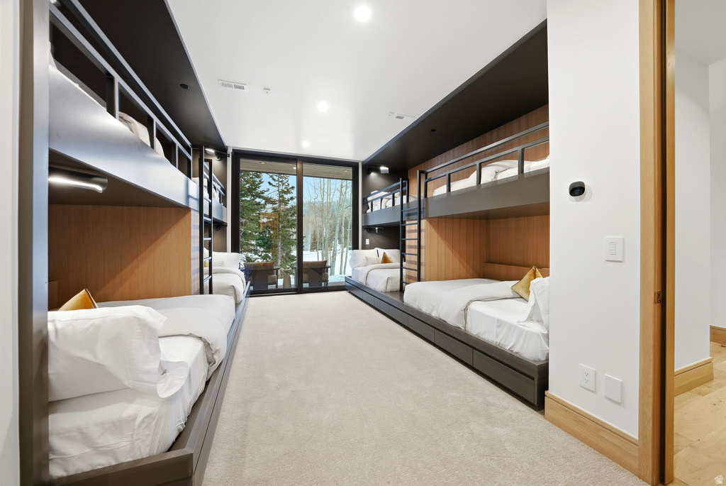 Bedroom featuring access to exterior and floor to ceiling windows