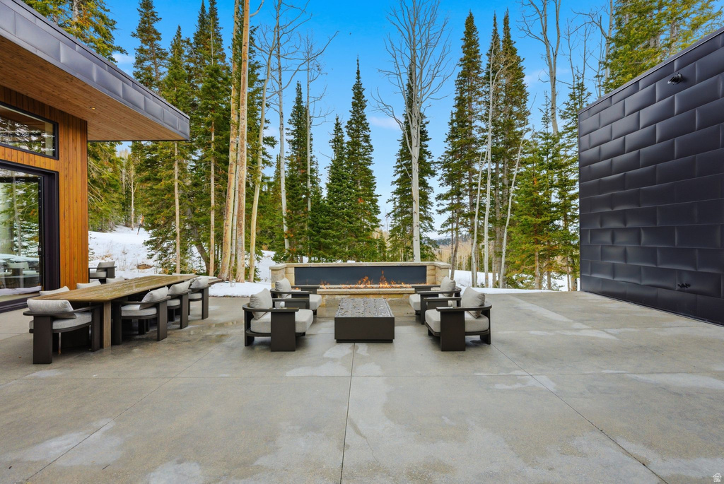 View of patio with outdoor dining space and an outdoor living space with a fire pit