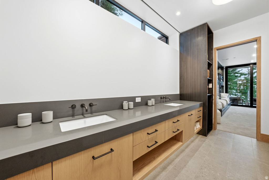 Bathroom featuring double vanity, recessed lighting, and ensuite bath