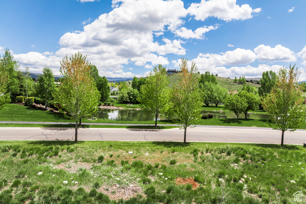 View of home\'s community featuring a water view and a yard