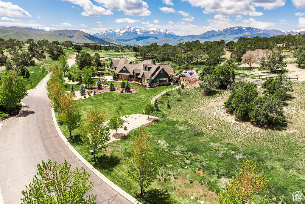 Aerial view of property and surrounding area featuring a mountainous background
