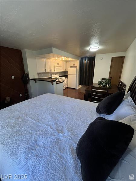 Bedroom with freestanding refrigerator