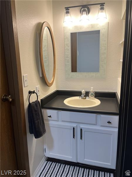 Bathroom with vanity and a textured wall