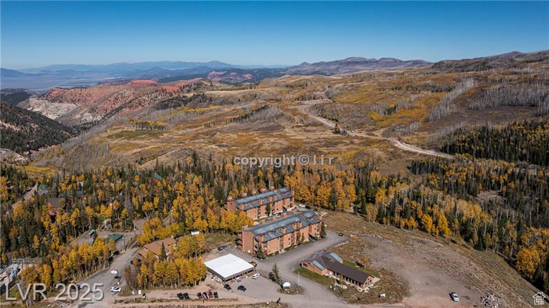 Aerial view of property's location with mountains and a heavily wooded area