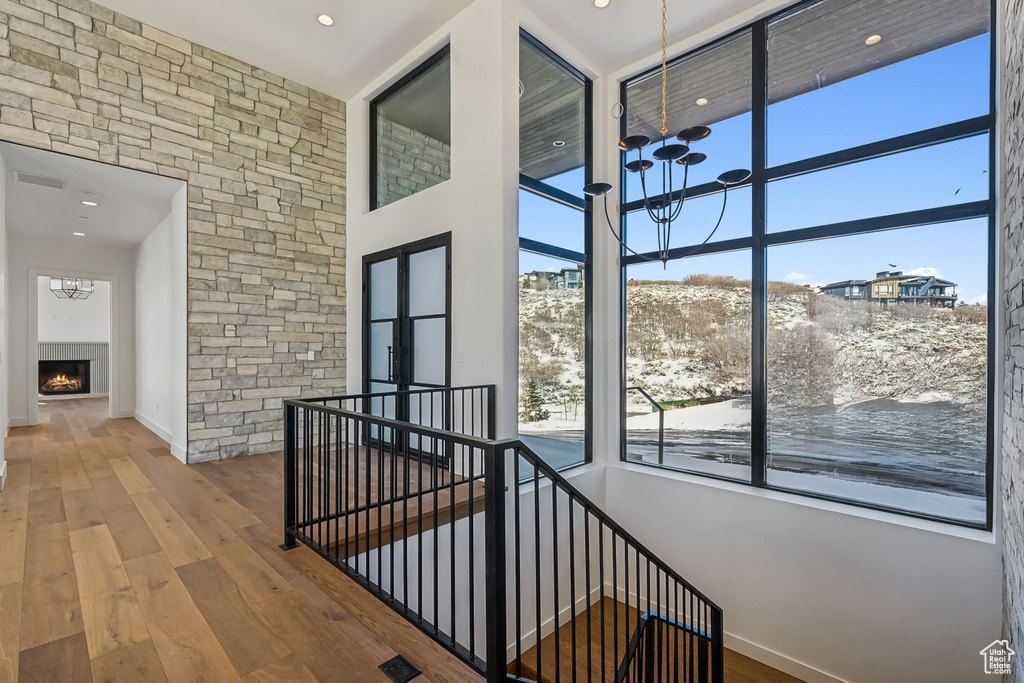 Hallway featuring a chandelier, an upstairs landing, hardwood / wood-style floors, and recessed lighting