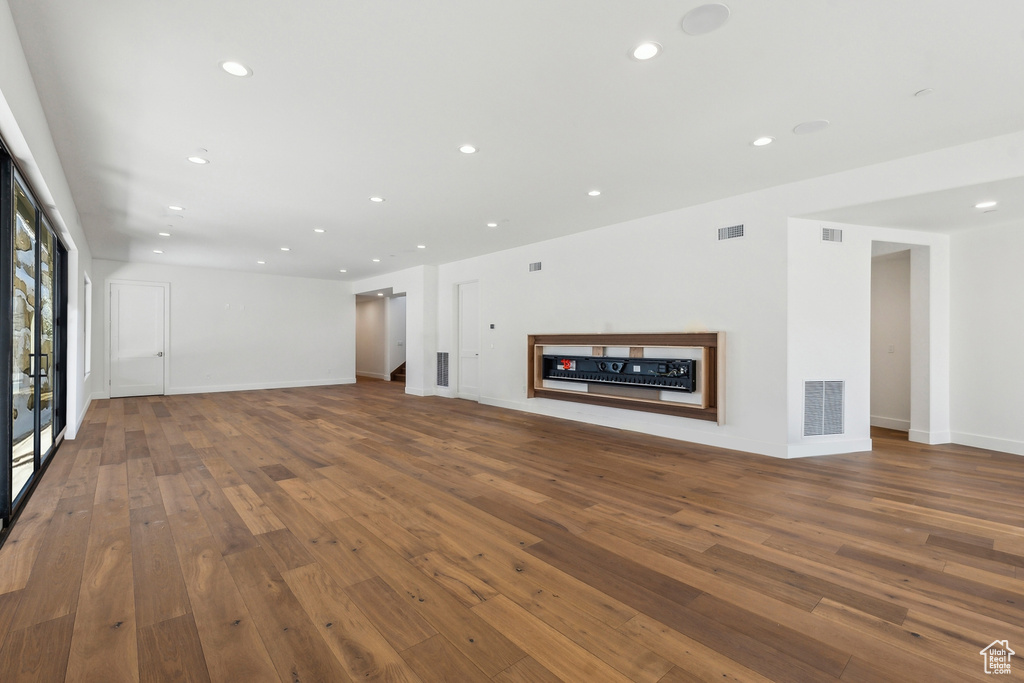 Unfurnished living room featuring a fireplace, wood-type flooring, and recessed lighting