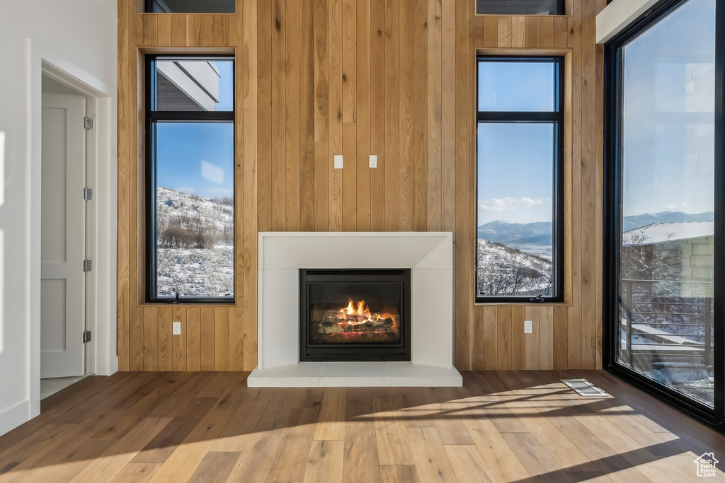 Detailed view of wooden walls, a glass covered fireplace, and wood finished floors