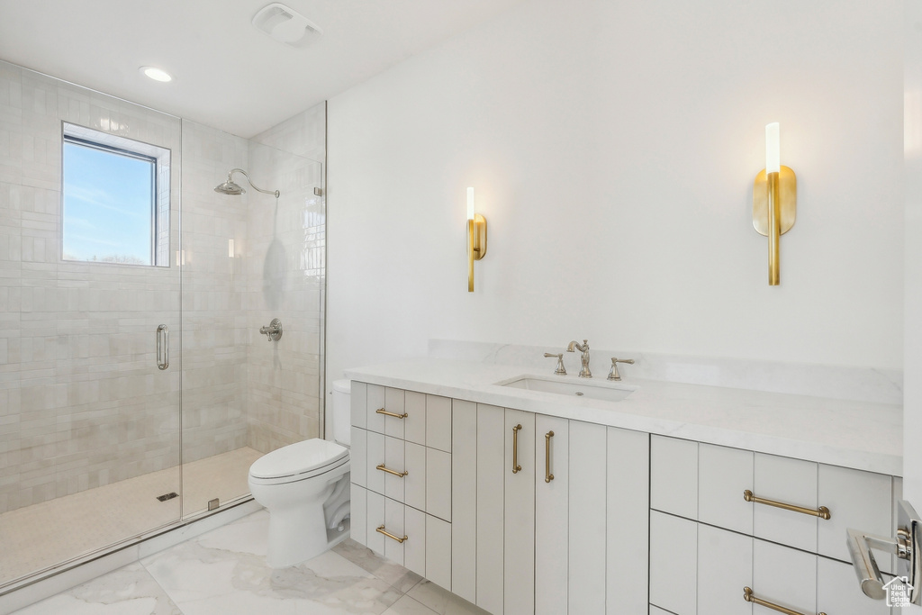 Bathroom featuring a stall shower, marble finish flooring, and vanity