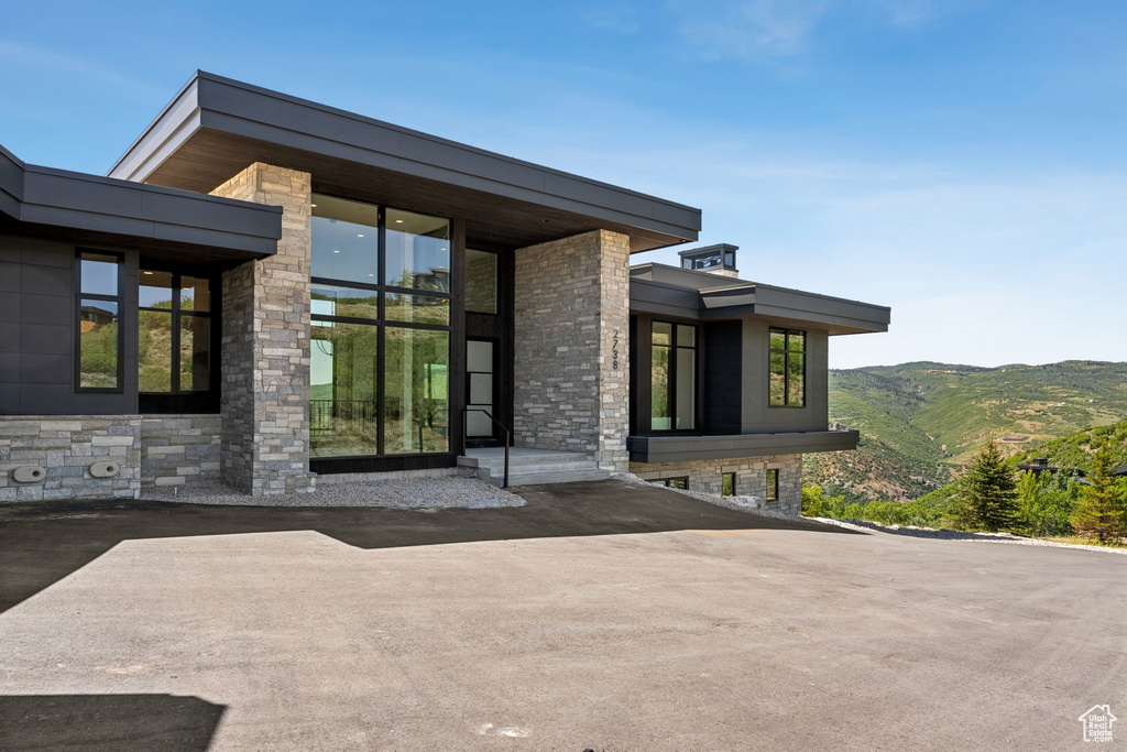 Doorway to property featuring stone siding and a mountain view