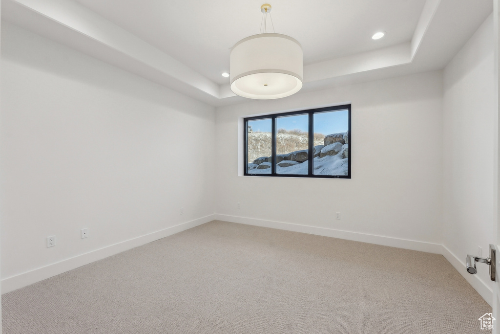 Unfurnished room featuring a raised ceiling, recessed lighting, and light colored carpet
