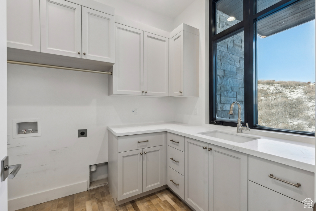 Laundry area with hookup for a washing machine, hookup for an electric dryer, healthy amount of natural light, and light wood-type flooring