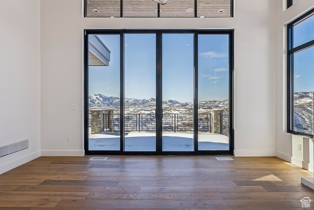 Unfurnished room with a mountain view and wood finished floors