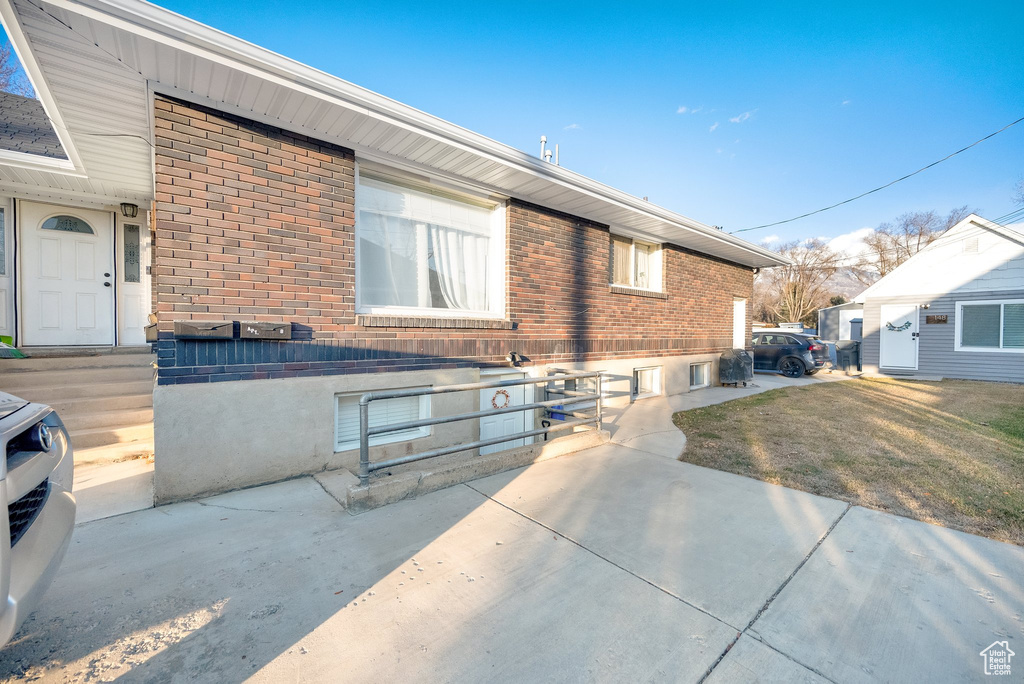 View of front of home with a patio and a front yard