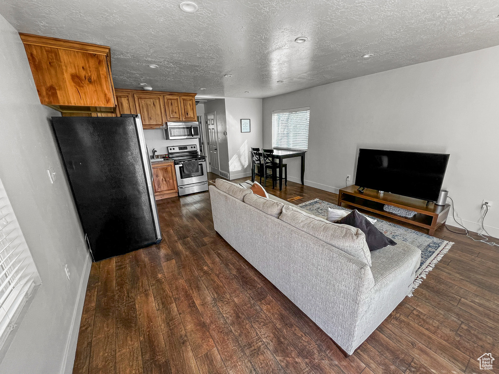 Living room featuring dark hardwood / wood-style flooring and a textured ceiling