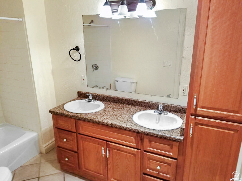 Full bathroom with vanity, bathtub / shower combination, tile patterned floors, and toilet