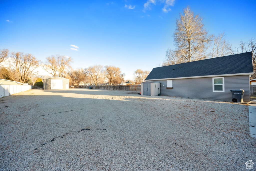 View of side of home with a garage and a storage shed
