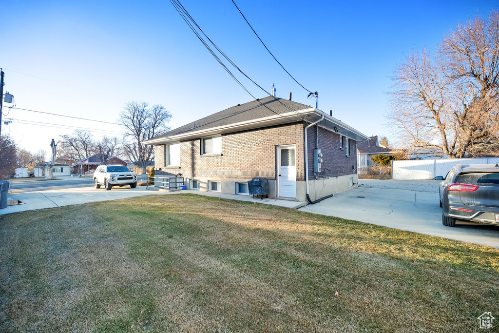 View of property exterior featuring a yard and a patio
