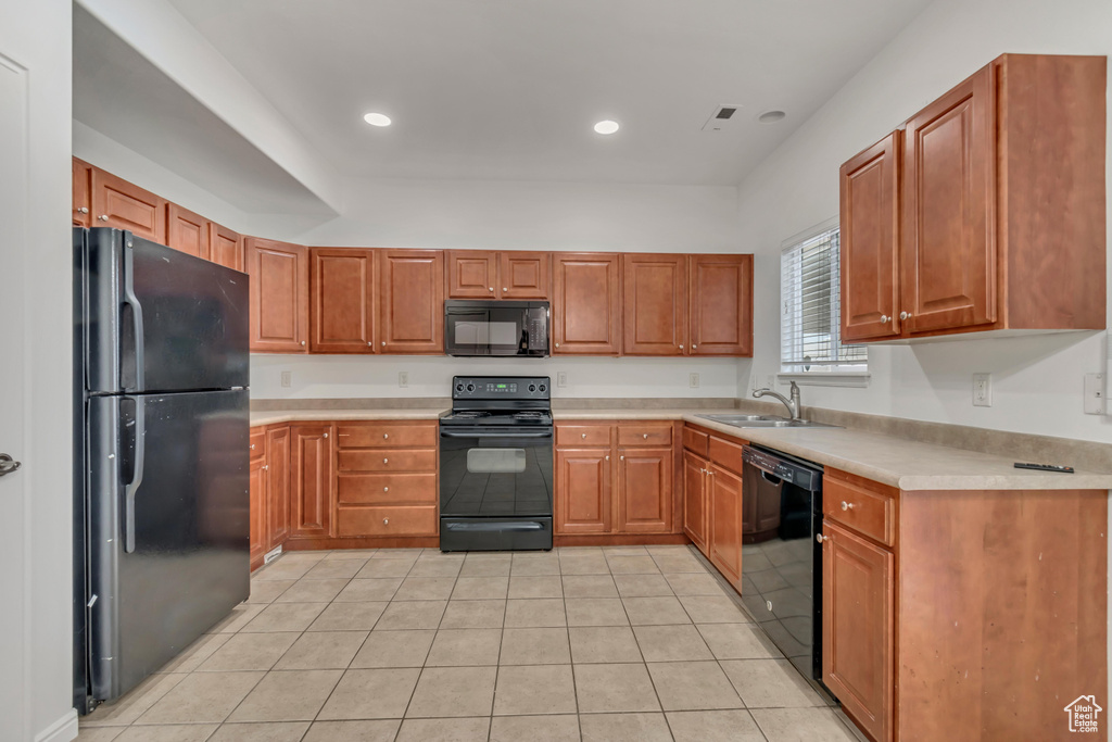 Kitchen featuring light tile patterned flooring, sink, and black appliances