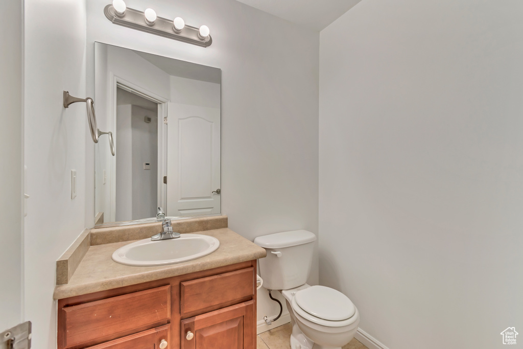 Bathroom featuring vanity, tile patterned floors, and toilet