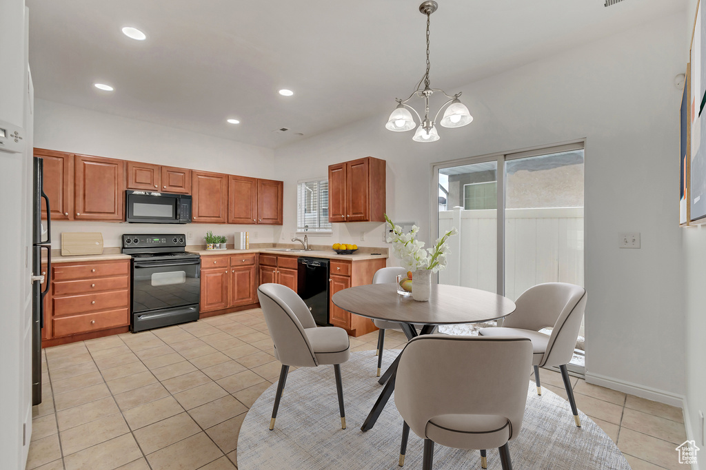 Kitchen featuring light tile patterned floors, recessed lighting, light countertops, a sink, and black appliances