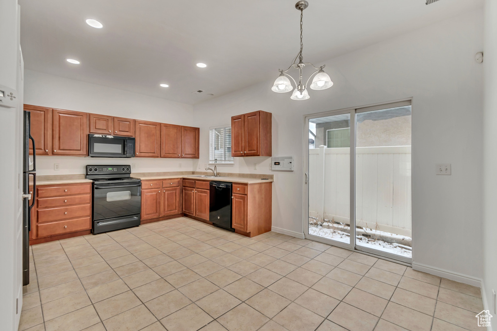 Kitchen with hanging light fixtures, sink, a notable chandelier, and black appliances