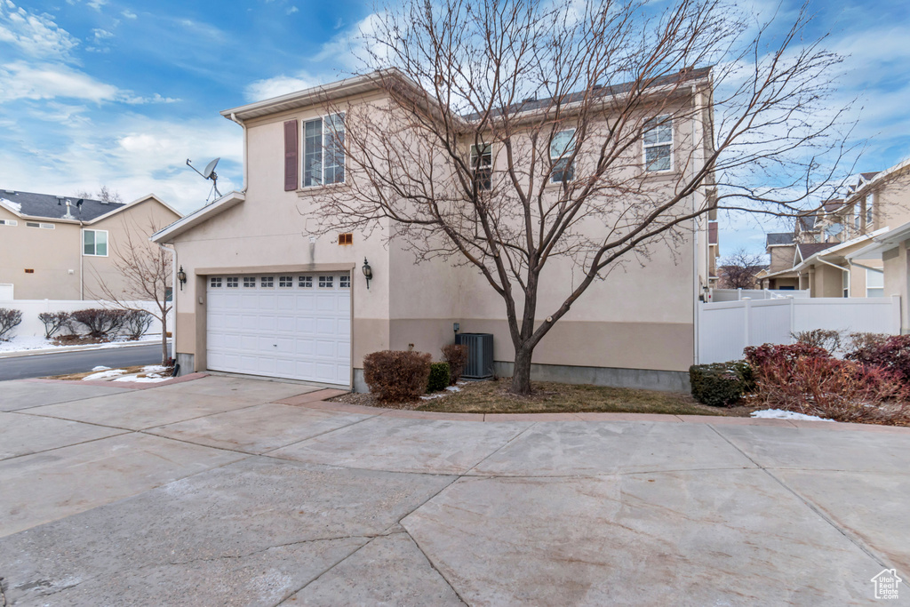 Front of property with a garage and central AC