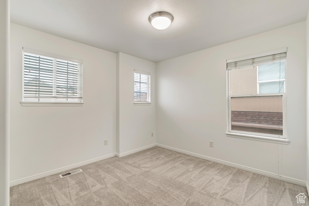 Unfurnished room featuring light colored carpet