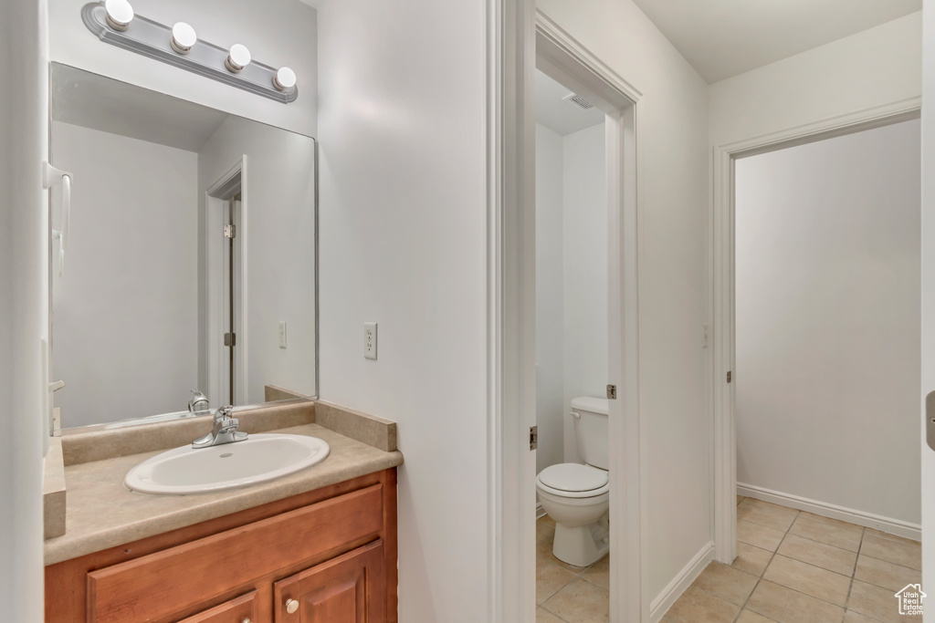 Bathroom featuring tile patterned flooring, vanity, and toilet