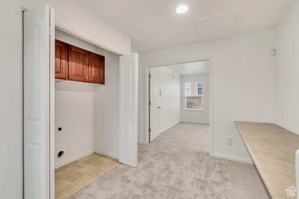 Laundry room featuring cabinets, light colored carpet, and electric dryer hookup