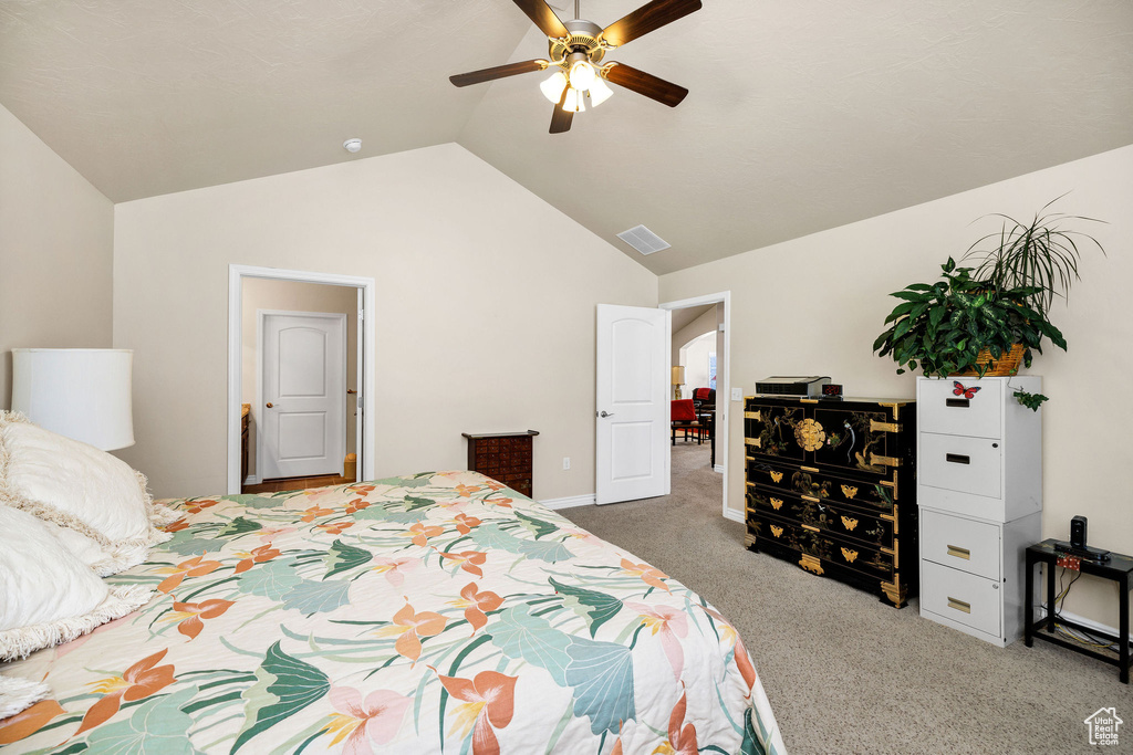 Carpeted bedroom featuring ceiling fan and lofted ceiling