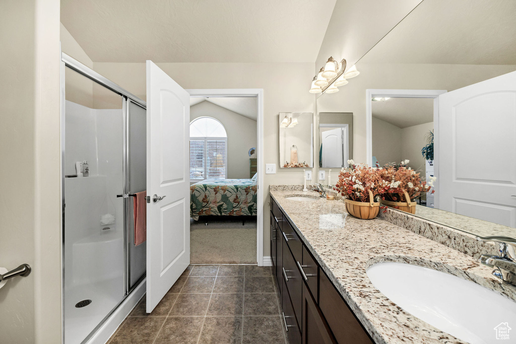 Bathroom featuring vanity, a shower with shower door, and tile patterned flooring