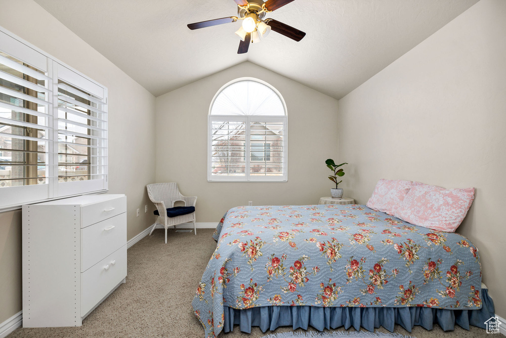 Bedroom with vaulted ceiling, light colored carpet, and ceiling fan