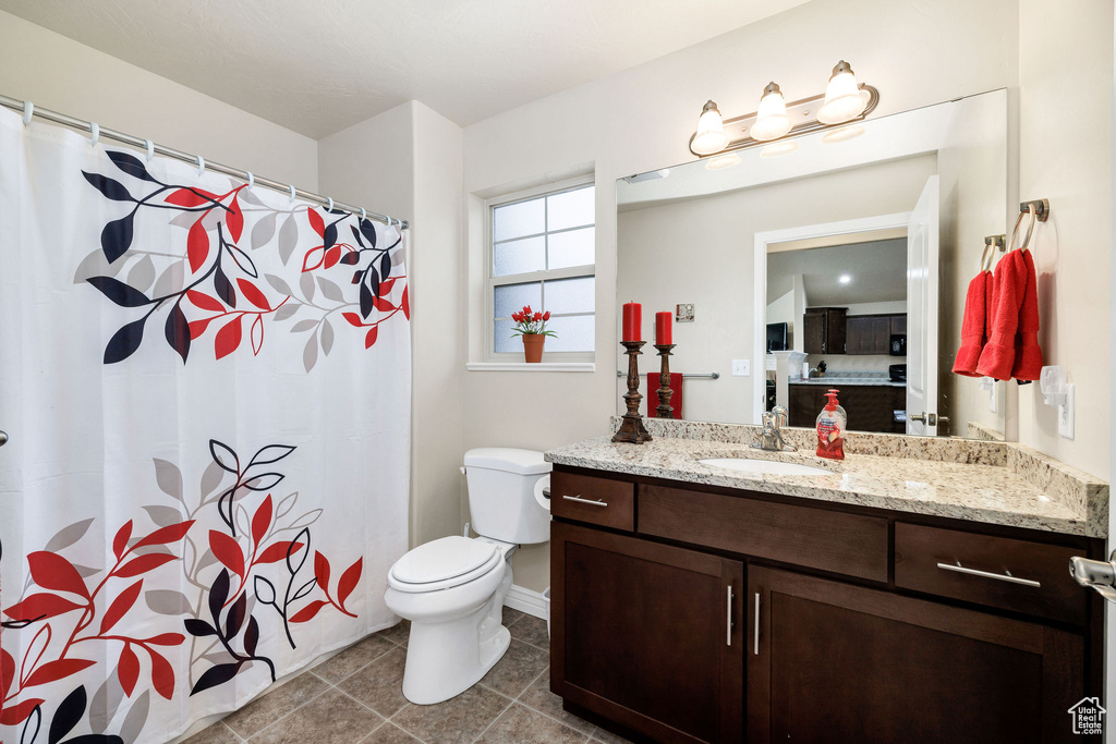 Bathroom featuring vanity, tile patterned floors, and toilet