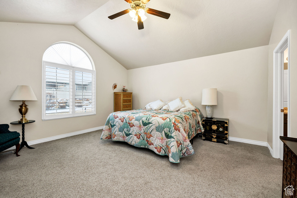 Bedroom featuring ceiling fan, lofted ceiling, and carpet flooring