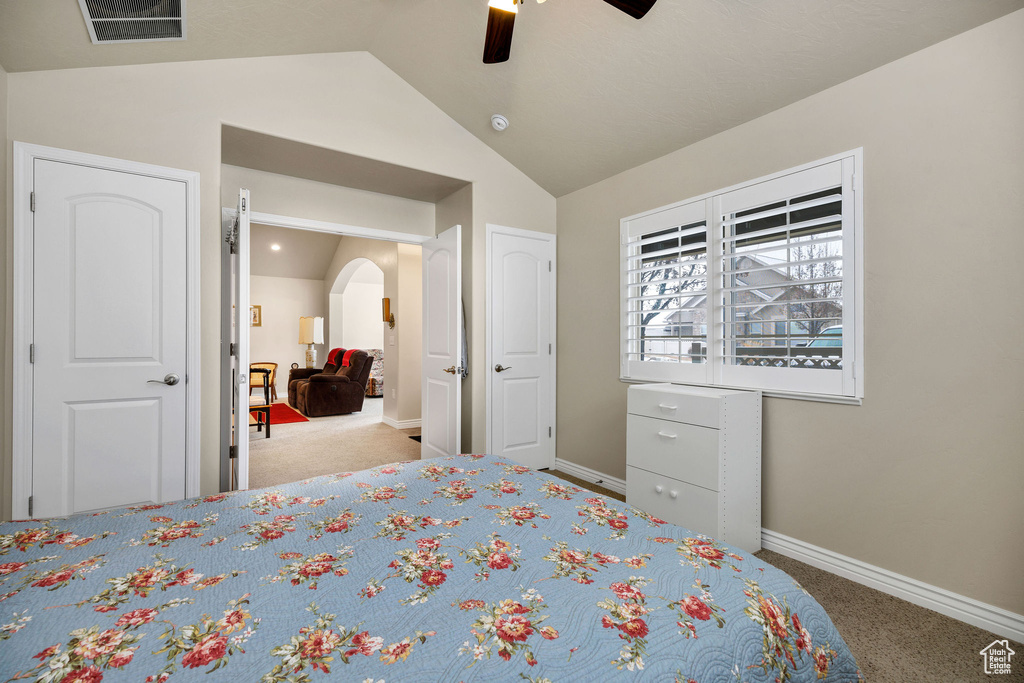 Bedroom featuring lofted ceiling, light colored carpet, and ceiling fan