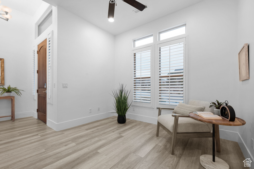 Living area with light hardwood / wood-style floors and ceiling fan