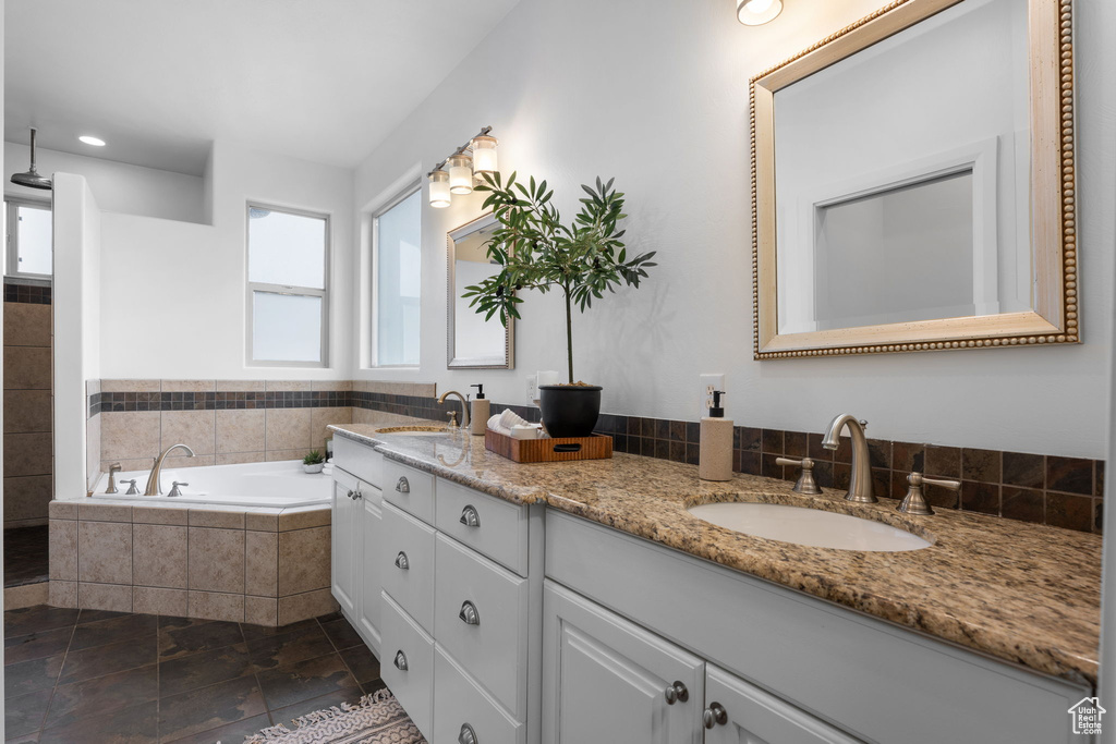 Bathroom with vanity and tiled bath