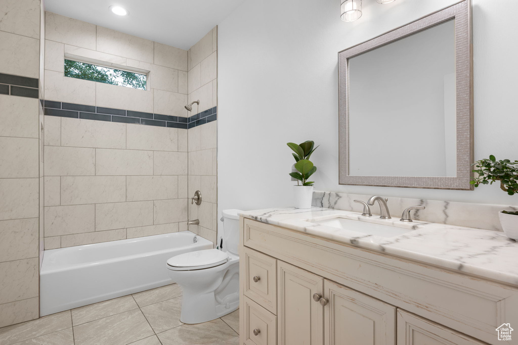 Full bathroom featuring tile patterned floors, toilet, tiled shower / bath combo, and vanity