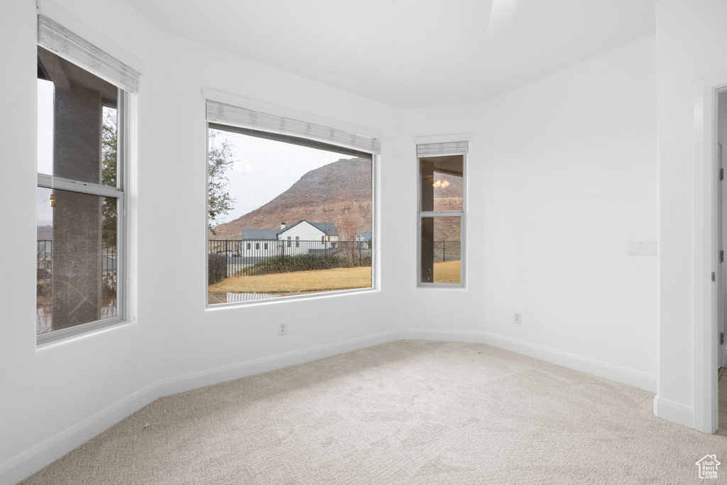 Spare room with a mountain view and carpet