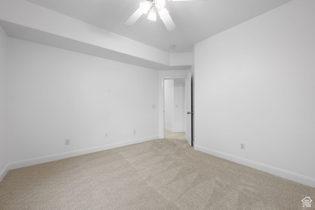 Carpeted empty room featuring ceiling fan