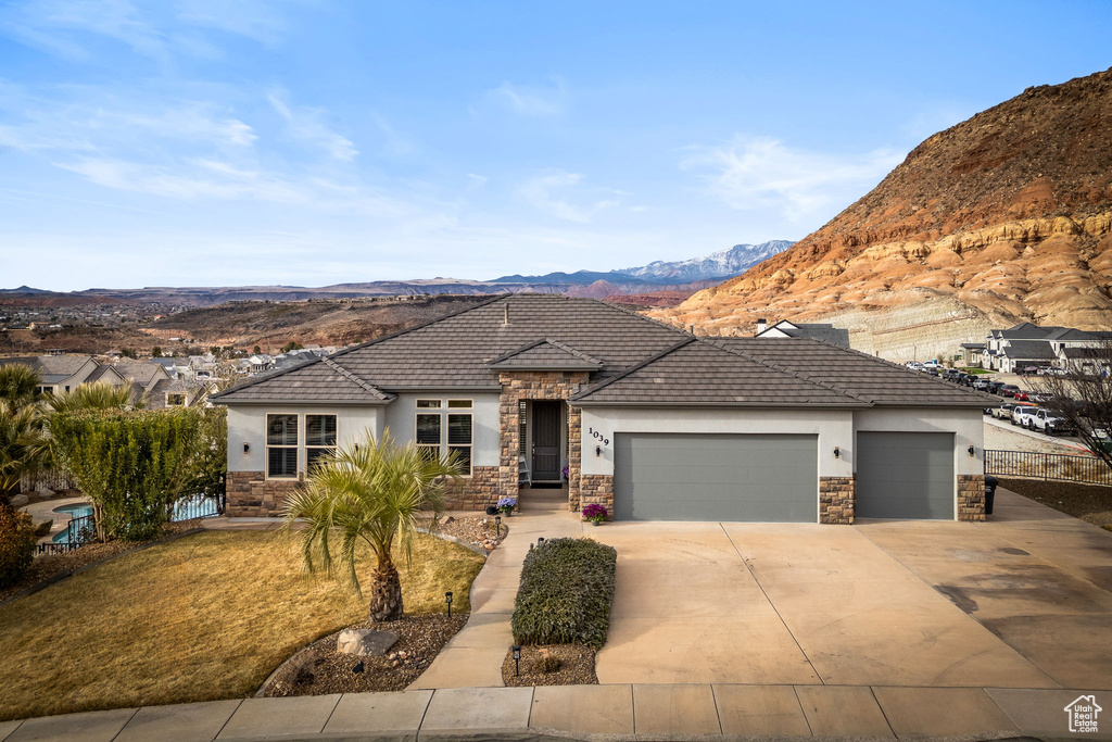 View of front facade featuring a mountain view and a garage