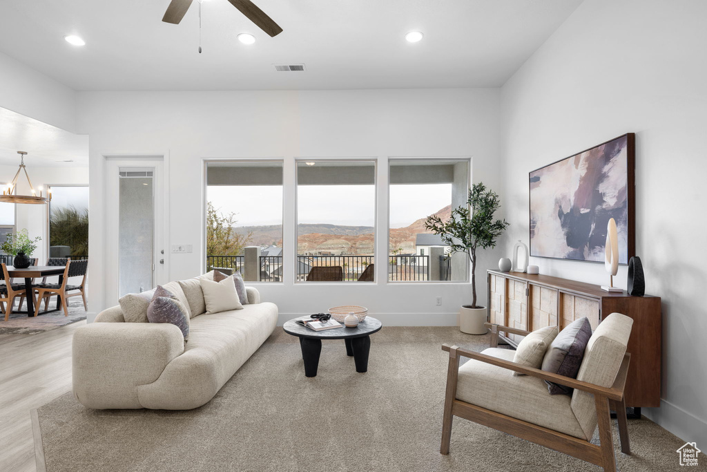 Living room featuring a mountain view, ceiling fan with notable chandelier, and light hardwood / wood-style floors