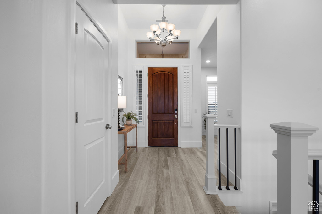 Entryway with an inviting chandelier and light hardwood / wood-style floors