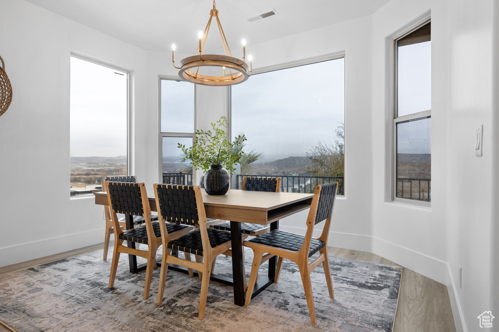 Dining space featuring wood-type flooring and a chandelier