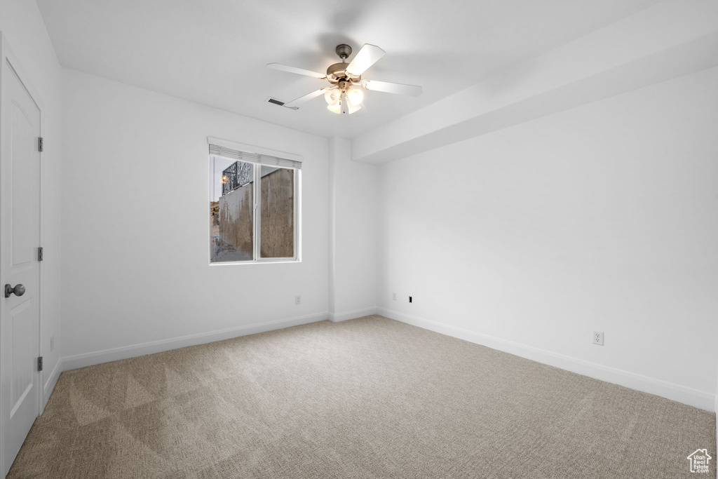 Unfurnished room featuring carpet and ceiling fan