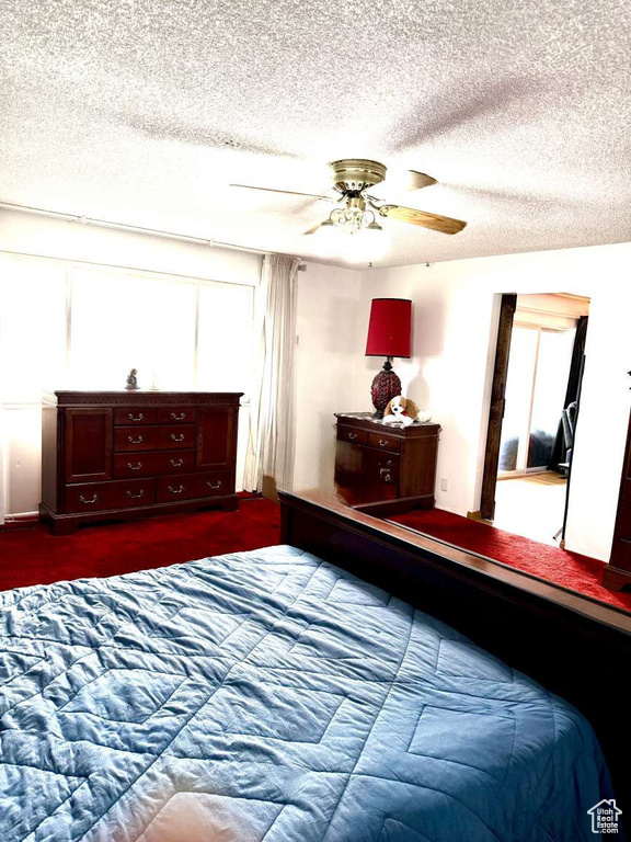 Bedroom with a textured ceiling and a ceiling fan