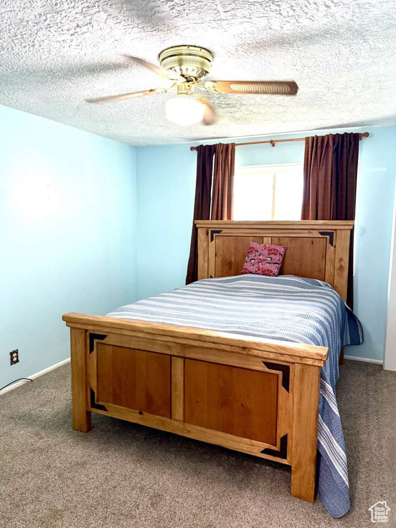 Bedroom featuring carpet flooring, ceiling fan, and a textured ceiling