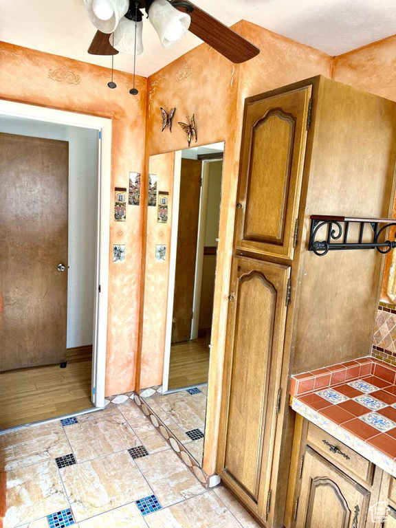 Bathroom with ceiling fan and tasteful backsplash