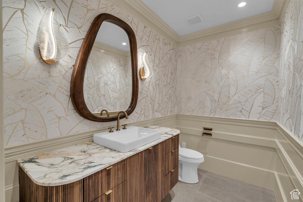 Bathroom featuring wallpapered walls, vanity, a wainscoted wall, crown molding, and recessed lighting