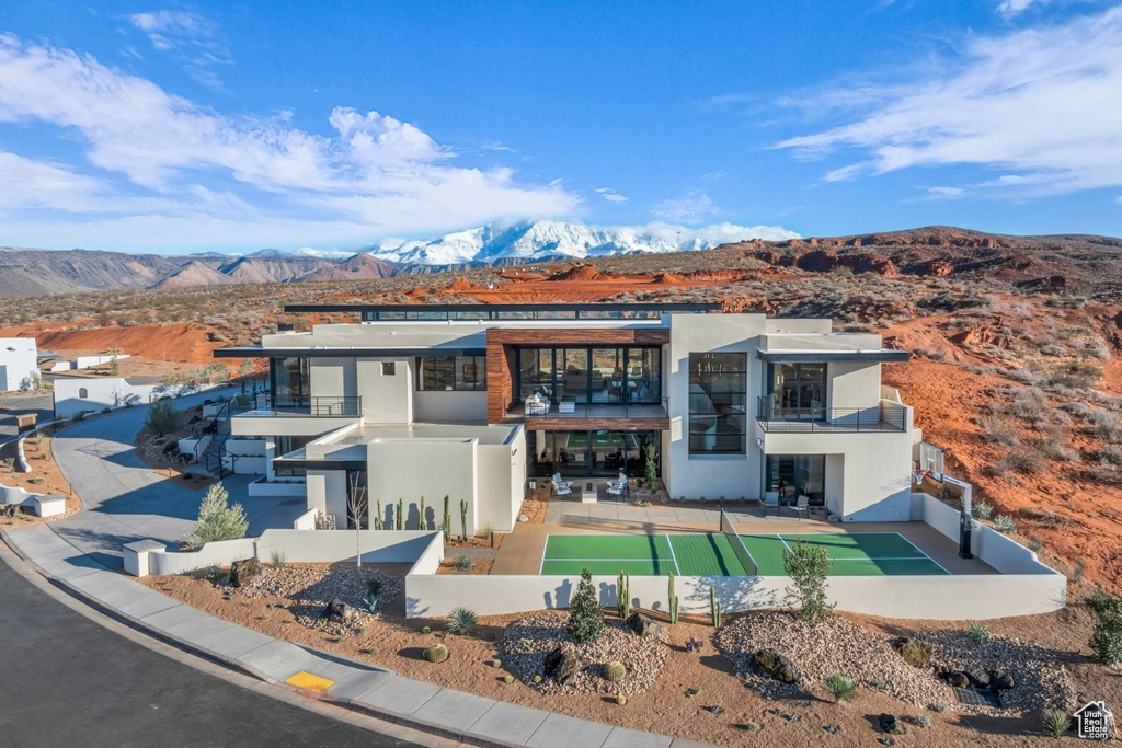 View of front of home with a balcony, stucco siding, and a mountain view